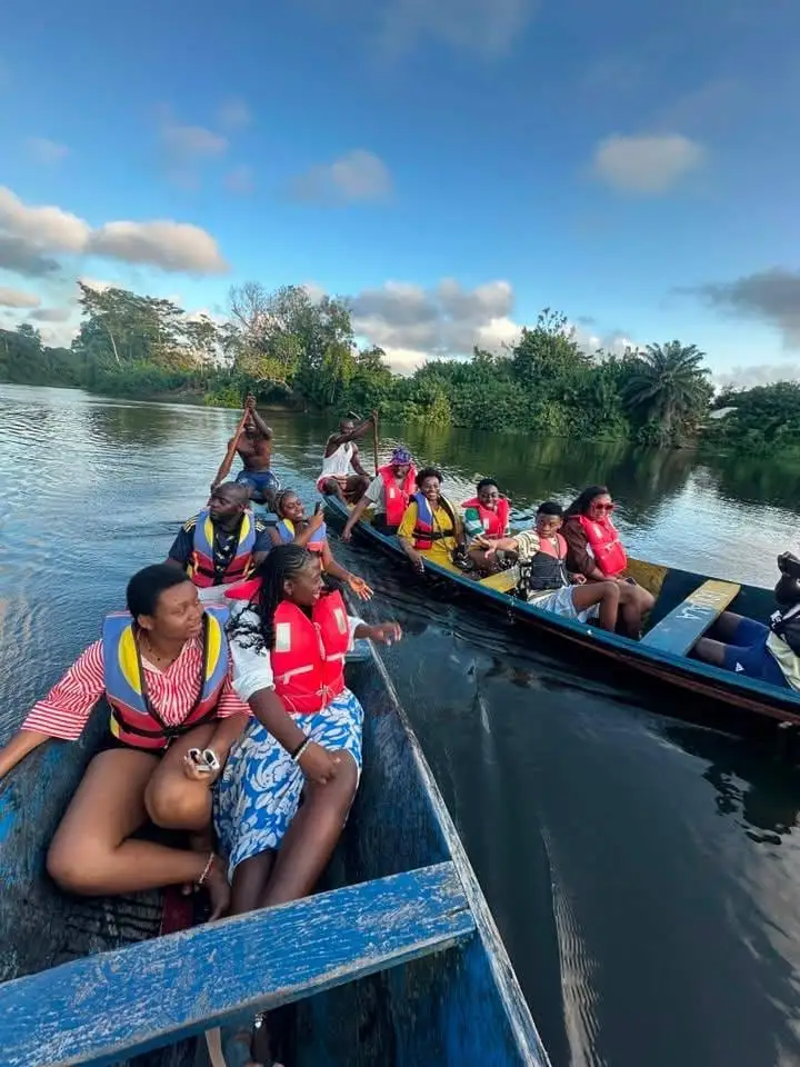 Des visiteurs en gilet de sauvetage remontent la rivière en pirogue