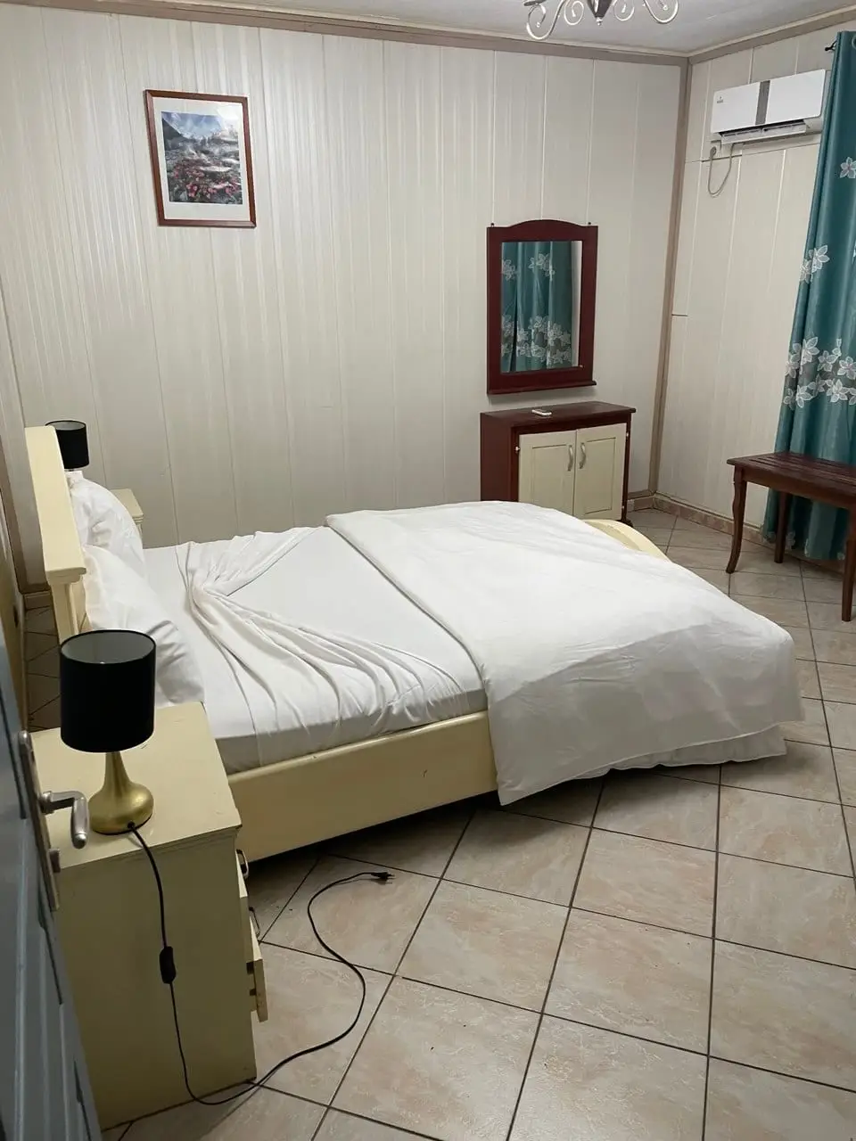 Une chambre avec lit double, climatisation et coiffeuse