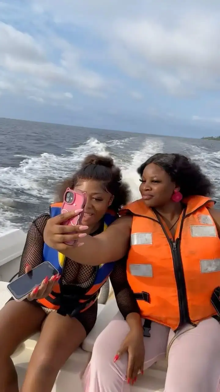 Deux passagères en gilet de sauvetage font un selfie à bord, en pleine mer