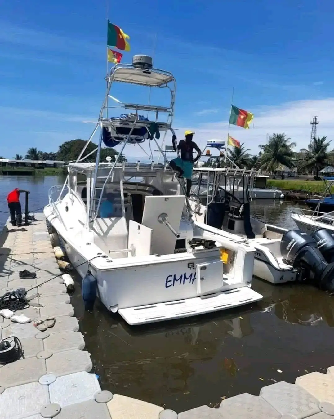 Un bateau de pêche au gros blanc, amarré au ponton sous les drapeaux du Cameroun