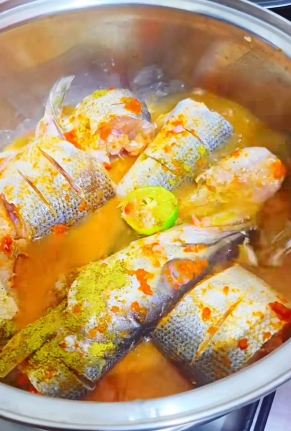 L’Ebanjea en cuisson : tronçons de poisson épicés et citron vert dans la marmite