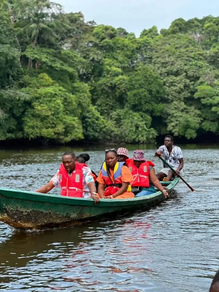 Des visiteurs en gilet de sauvetage dans une pirogue