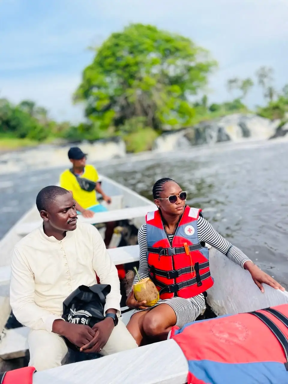 Deux visiteurs en pirogue devant les chutes de la Lobé