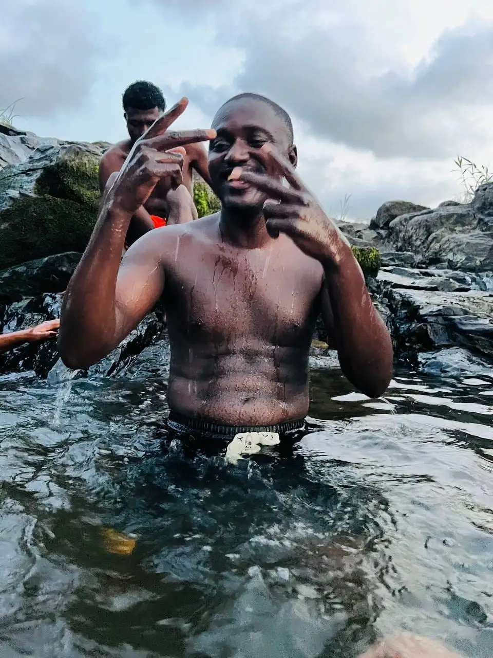 Un baigneur dans l'eau du jacuzzi naturel, entre les rochers