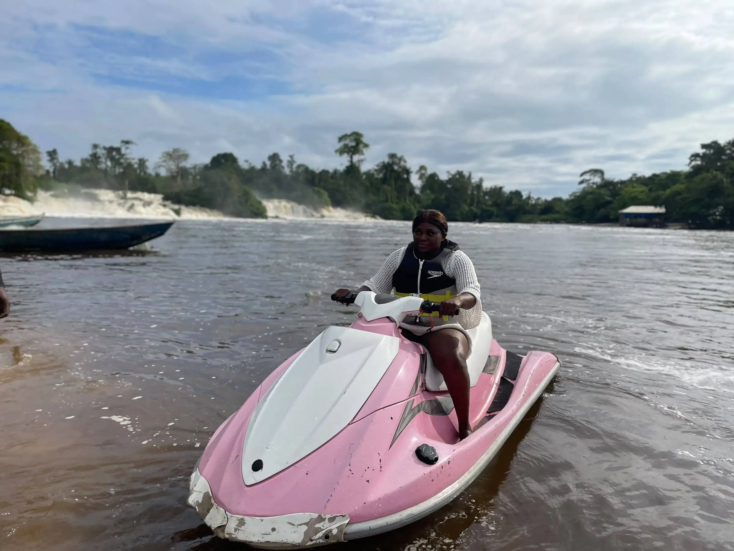 Un pilote sur un jet-ski rose, sur la rivière