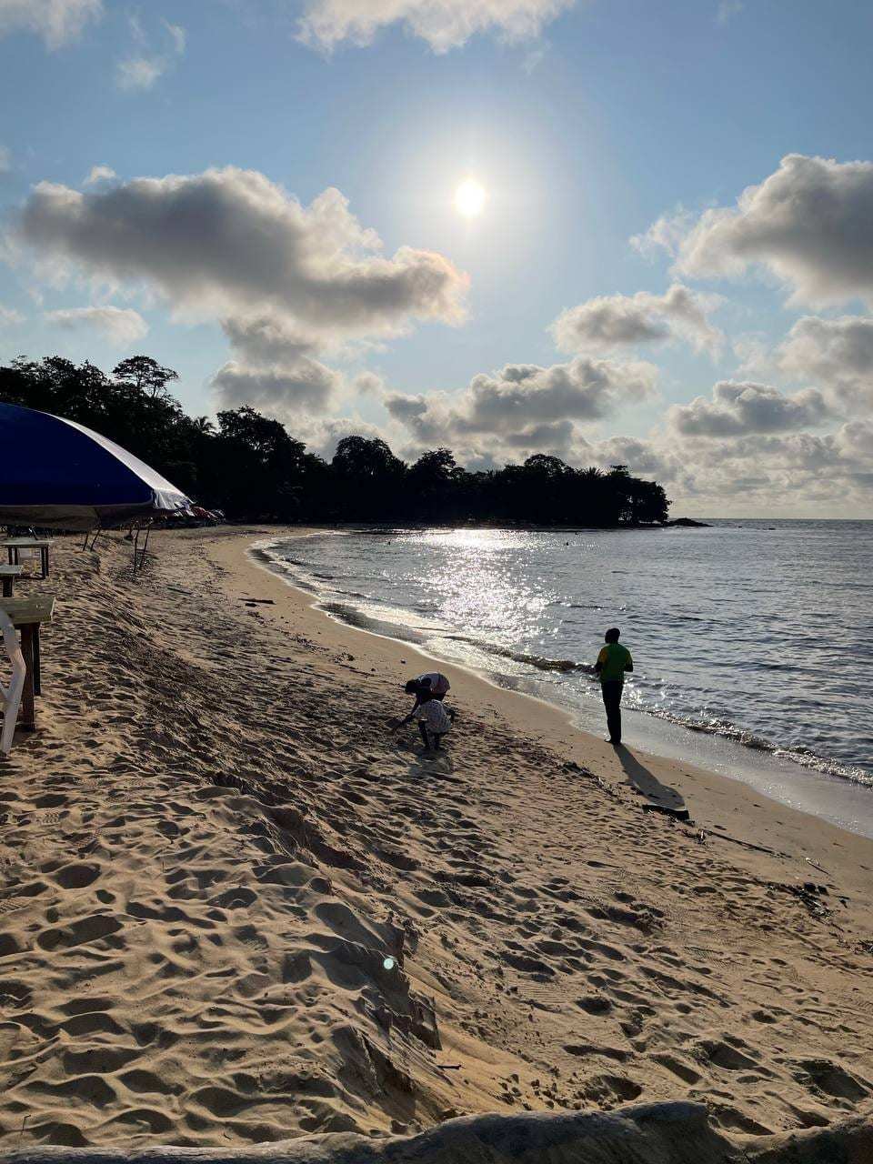 Une plage de Kribi bordée d’arbres, sous un soleil voilé