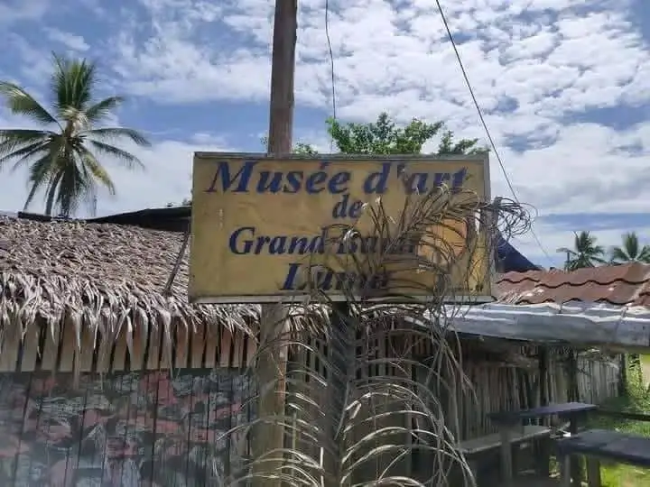 Le panneau « Musée d'art de Grand Batanga Luma » sous un ciel bleu