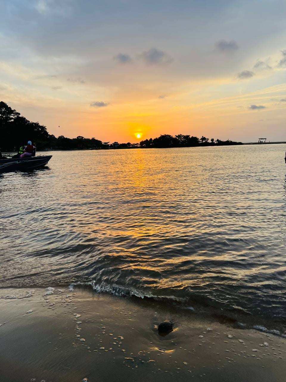 Coucher de soleil sur une plage de Kribi, une pirogue sur l’eau