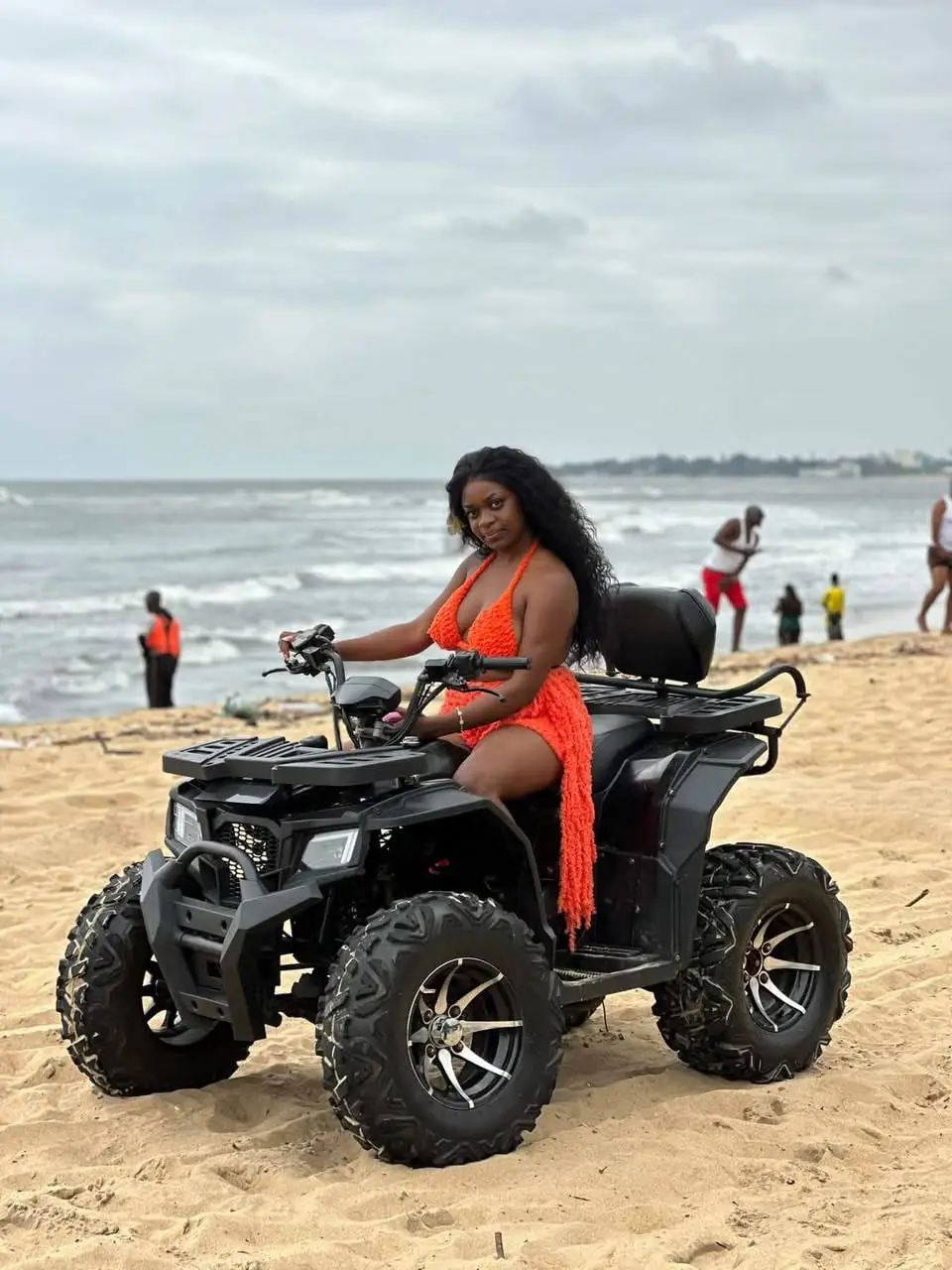 Une jeune femme sur un quad, au bord de la mer