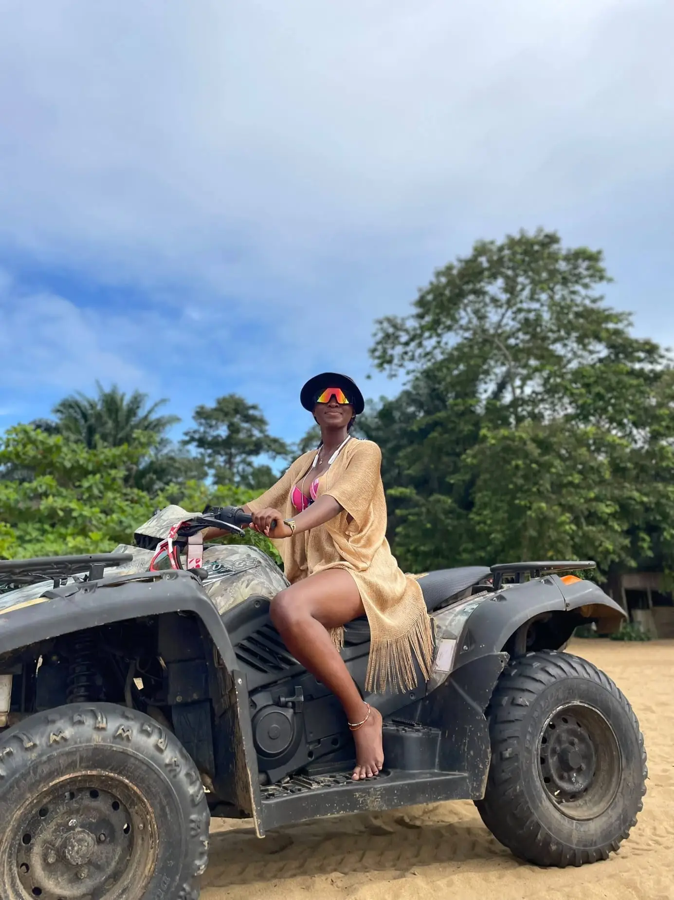 Une jeune femme sur un quad, sous le ciel bleu