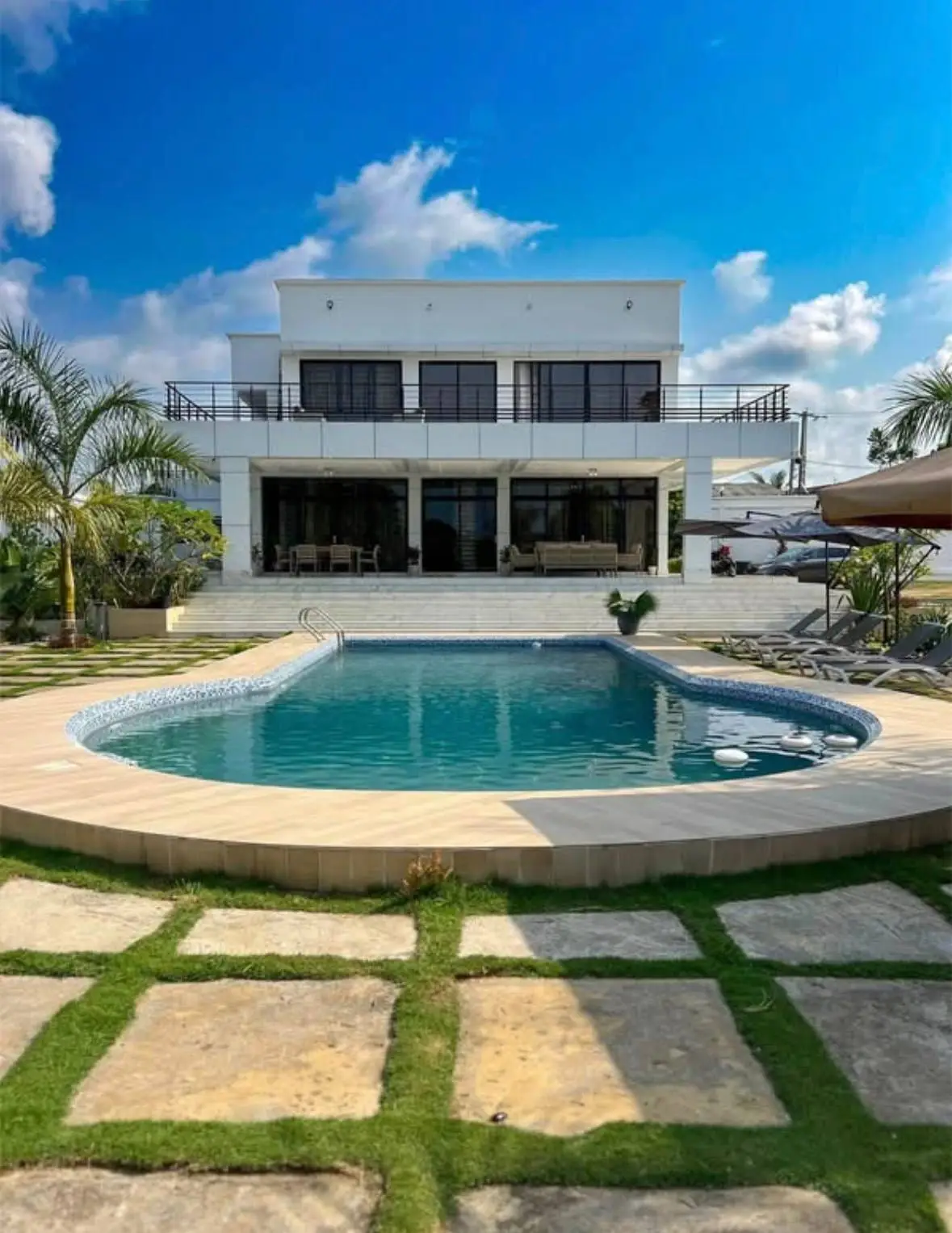Une villa blanche avec piscine et jardin