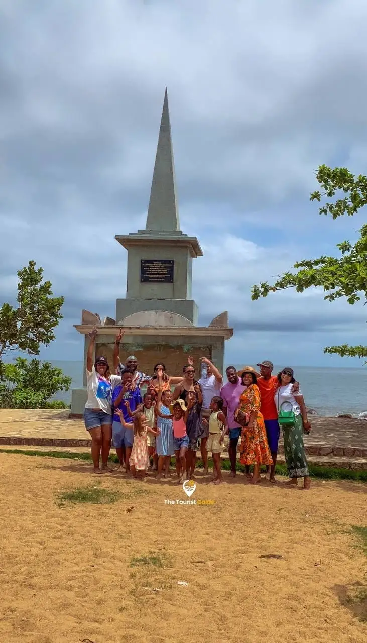 A group of visitors in front of the Mayi village monument