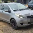 Une Toyota Yaris grise garée sur du gravier