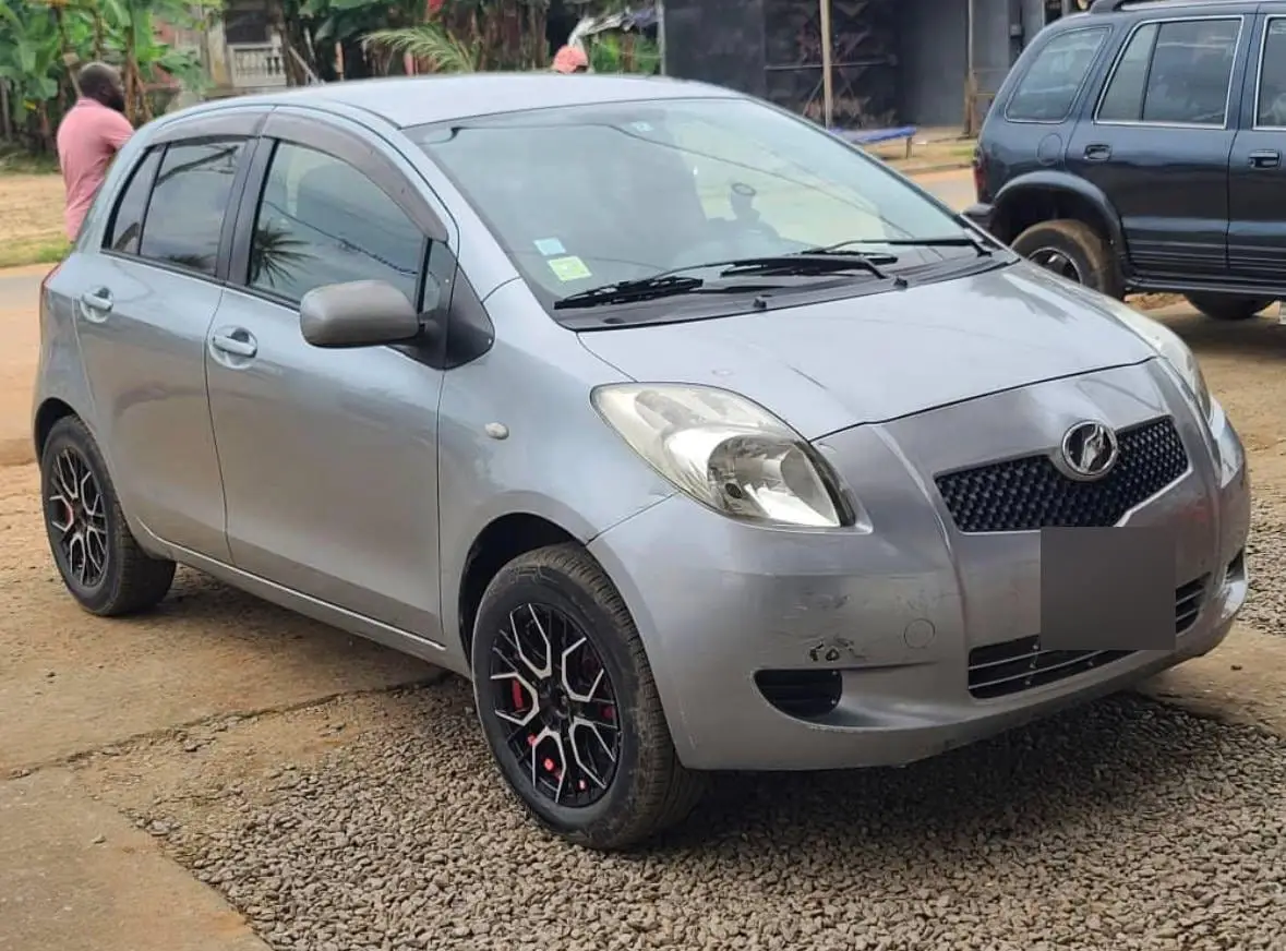 Une Toyota Yaris grise garée sur du gravier